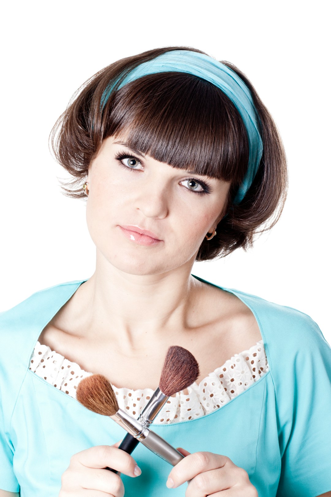 A woman is holding a brush and a makeup brush