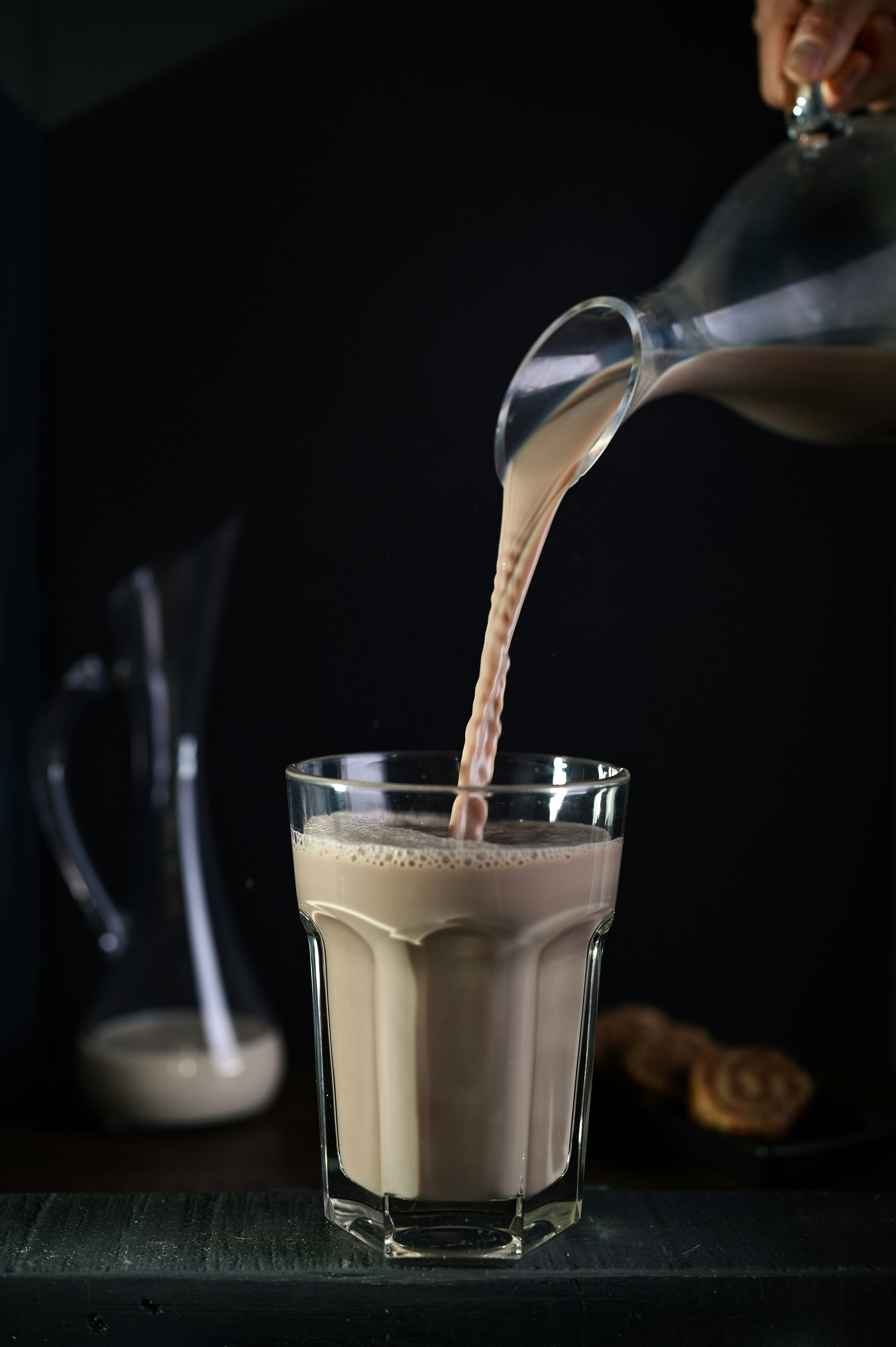 person pouring liquid on cup